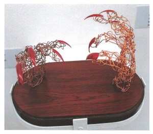 expressive wire hands with red talons displayed on wooden base