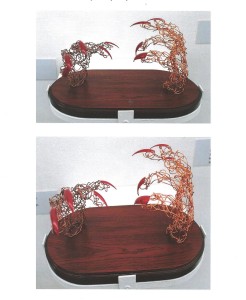  images of wire hands sculpture with red talons on wooden plinth