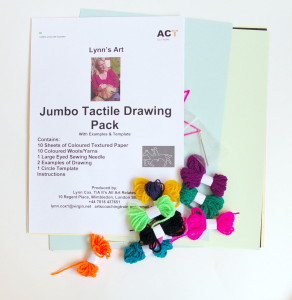 contents display of drawing pack, different coloured spools of yarn, needle, coloured textured paper